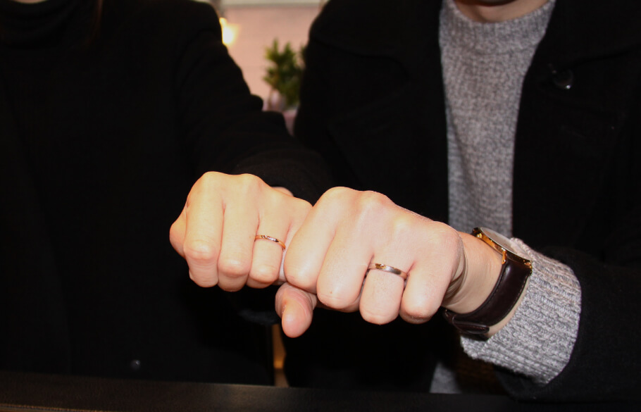 シンプルな結婚指輪をつけたカップル