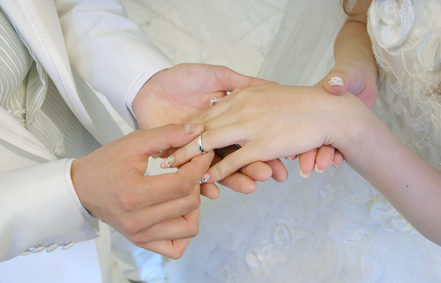 結婚式で指輪交換をしているカップルの手元