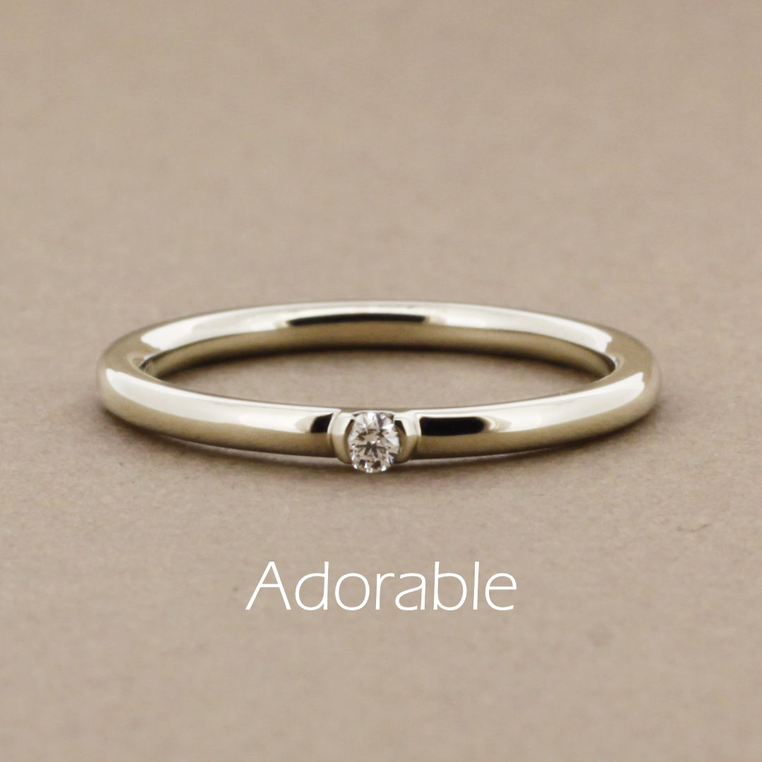 「adorable」という名前がついた、シンプルで細い丸みのあるアームに小さなダイヤモンドを1粒留めた、ハニーゴールドの指輪