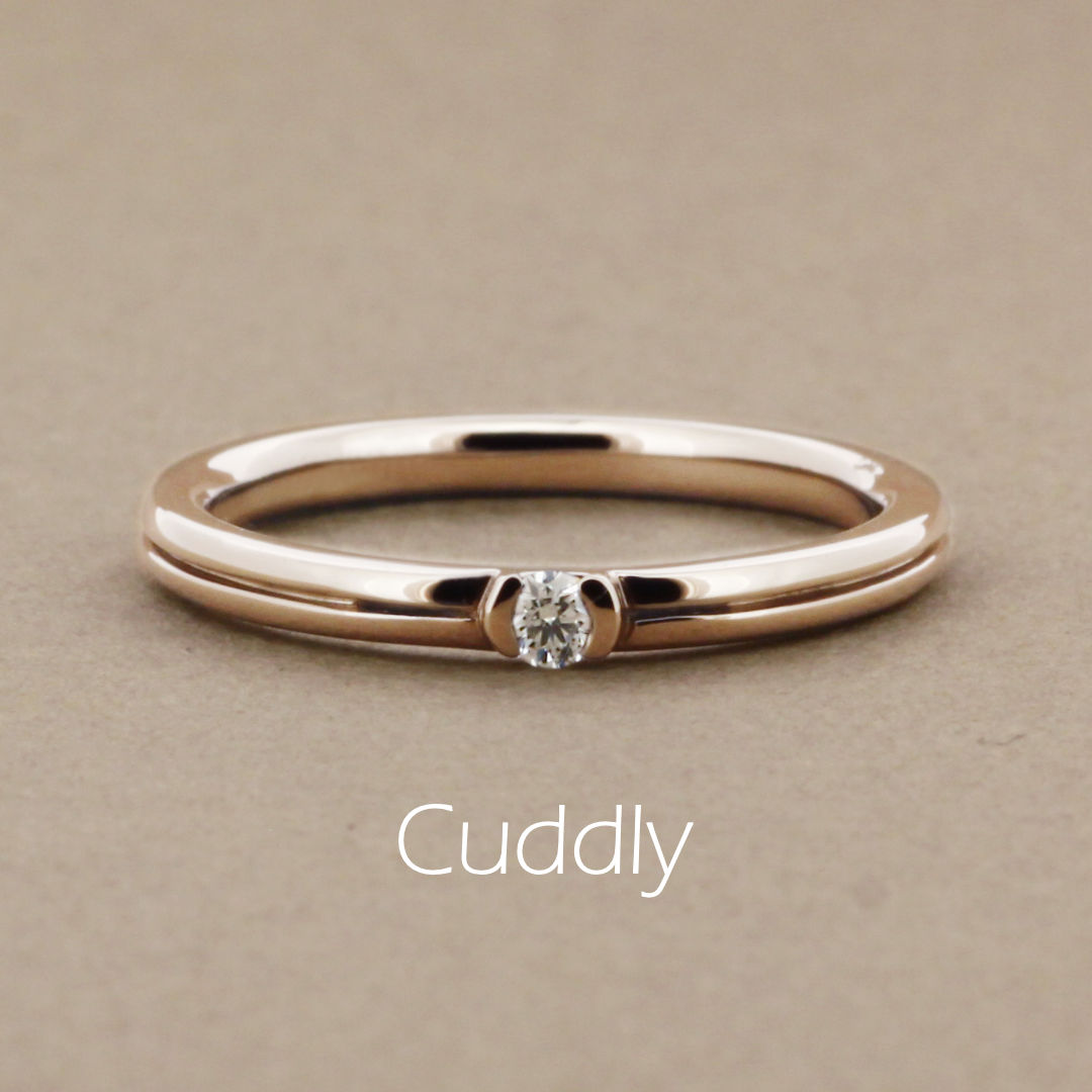 「Cuddly」という名前がついた、真ん中にラインが入った丸みのあるアームに1粒の小さなダイヤを留めたピンクゴールドの指輪