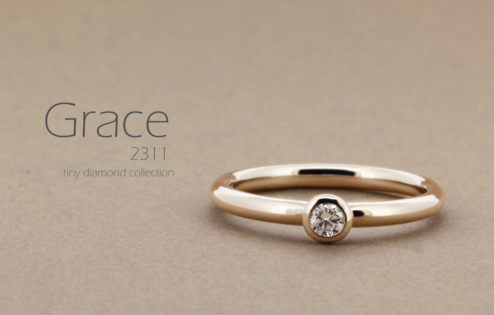 「Grace」という名前が付いた、シンプルで丸みのあるアームに0.1ctのダイヤモンドをフクリンで留めた指輪の詳細ページトップ