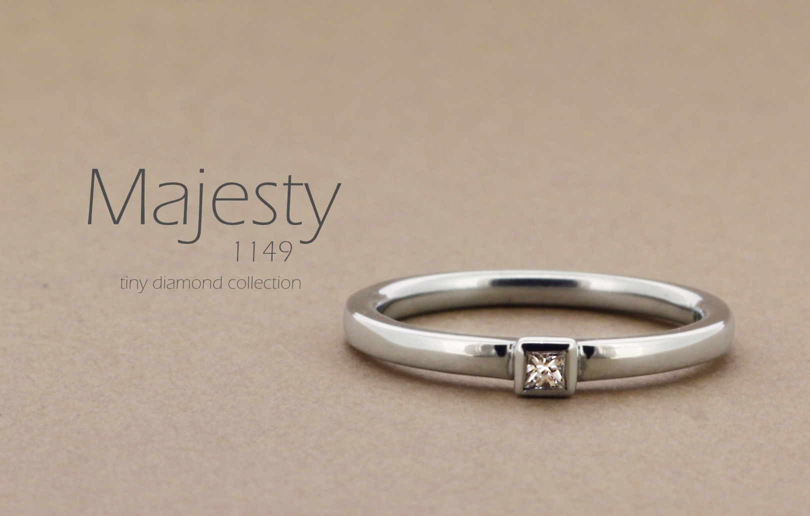「Majesty」という名前が付いた、シンプルなアームにプリンセスカットのダイヤモンドを留めた指輪の詳細ページ