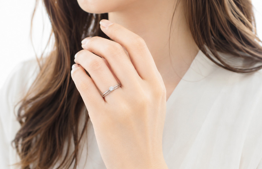 婚約指輪と結婚指輪を重ね着けした女性の手元
